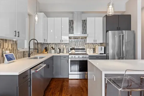 a kitchen with a sink a stove a refrigerator and cabinets