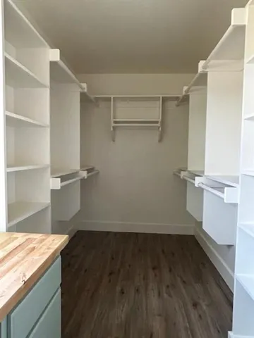 a view of a room with wooden floor and cabinets