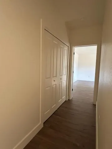 an empty room with wooden floor and door