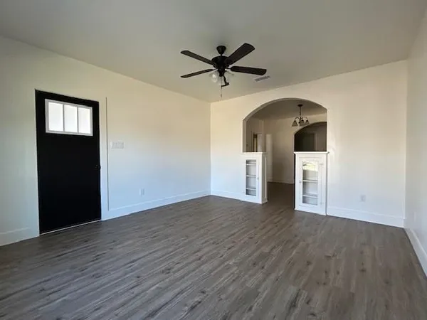 a view of a livingroom with wooden floor and a ceiling fan