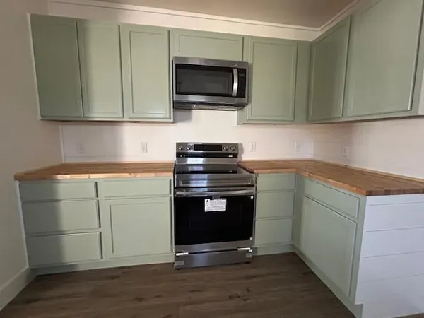 a kitchen with granite countertop a stove and a microwave