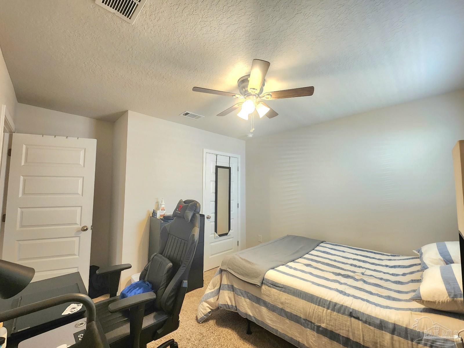 5379 Peach Drive Pace, FL 32571 - Photo 13 of 23 a bedroom with a bed and a chandelier