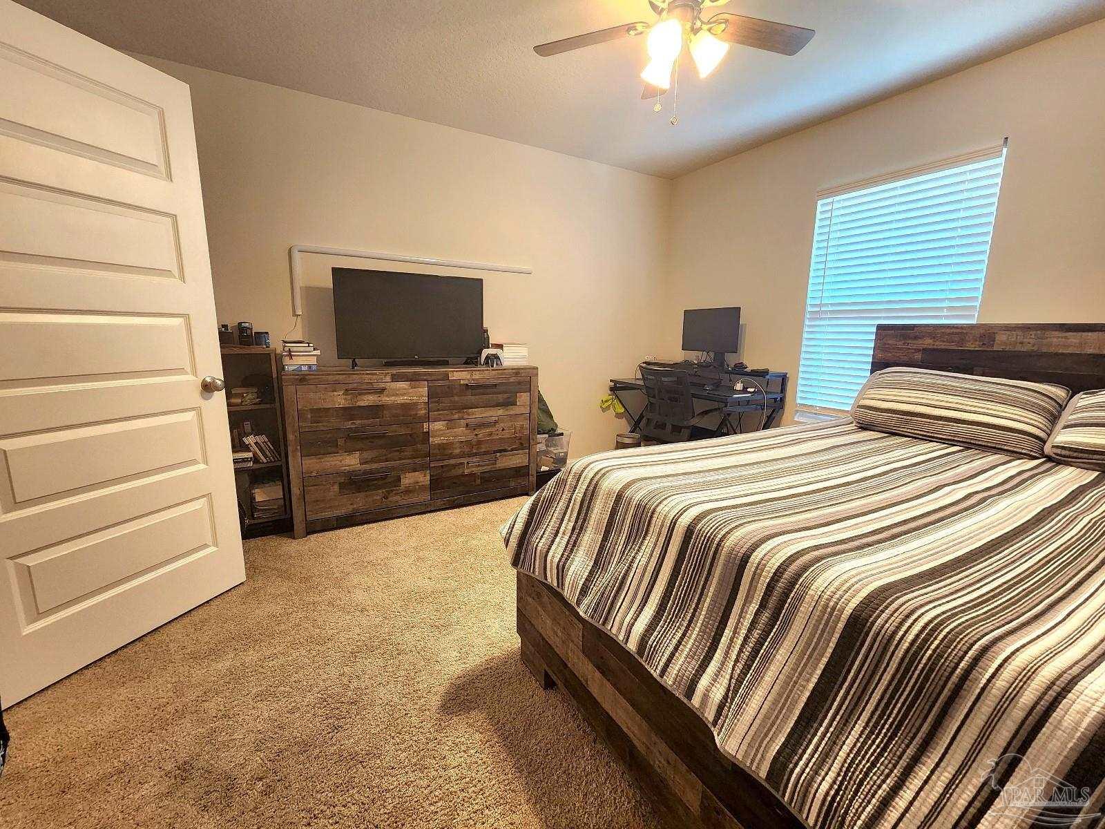 5379 Peach Drive Pace, FL 32571 - Photo 17 of 23 a bedroom with two beds and a chandelier