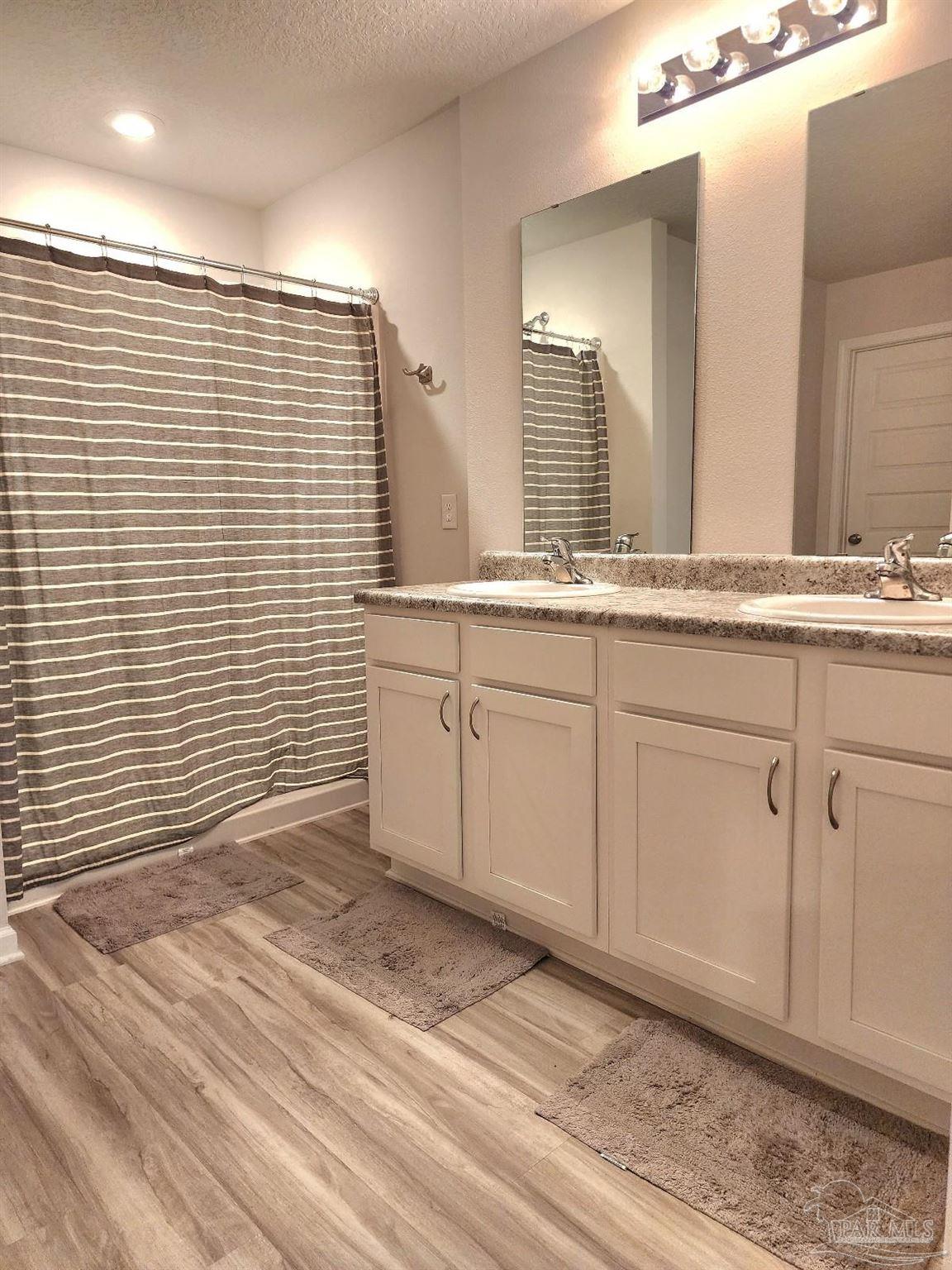 5379 Peach Drive Pace, FL 32571 - Photo 20 of 23 a view of a bathroom with a sink a mirror and a shower