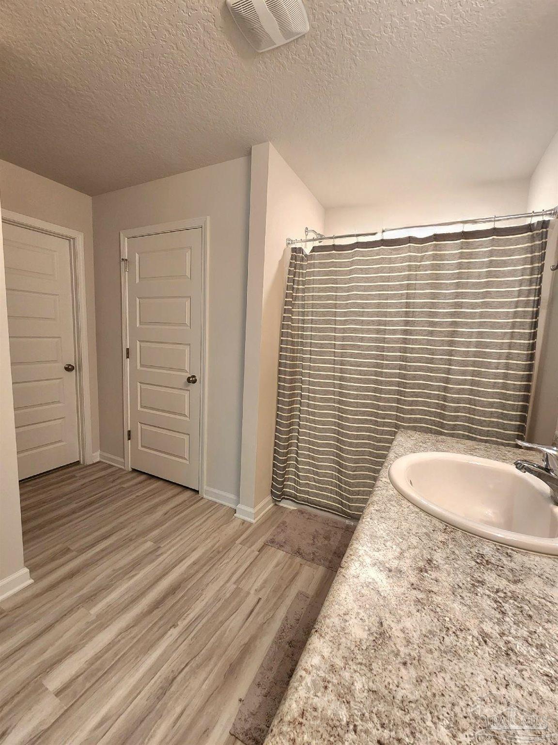 5379 Peach Drive Pace, FL 32571 - Photo 21 of 23 an empty room with wooden floor and bathroom