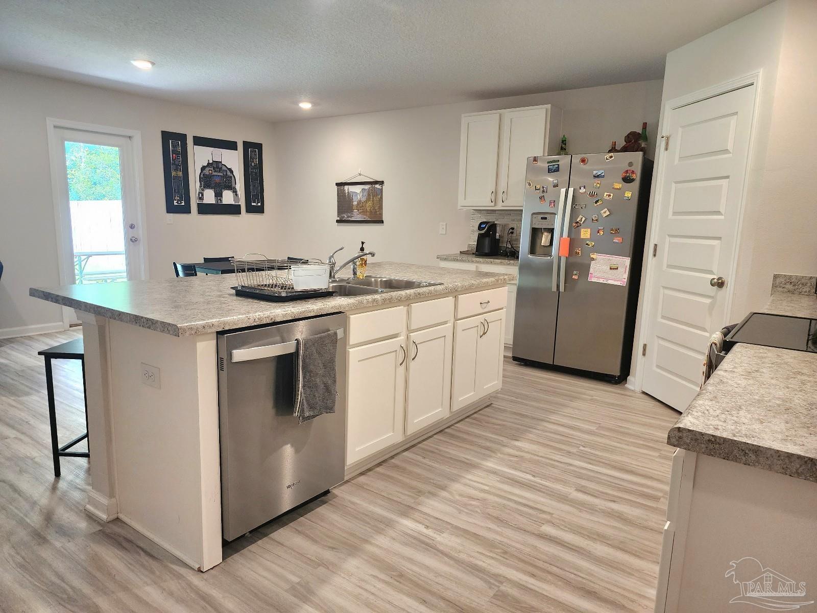 5379 Peach Drive Pace, FL 32571 - Photo 4 of 23 a kitchen with stainless steel appliances granite countertop a refrigerator and a stove top oven