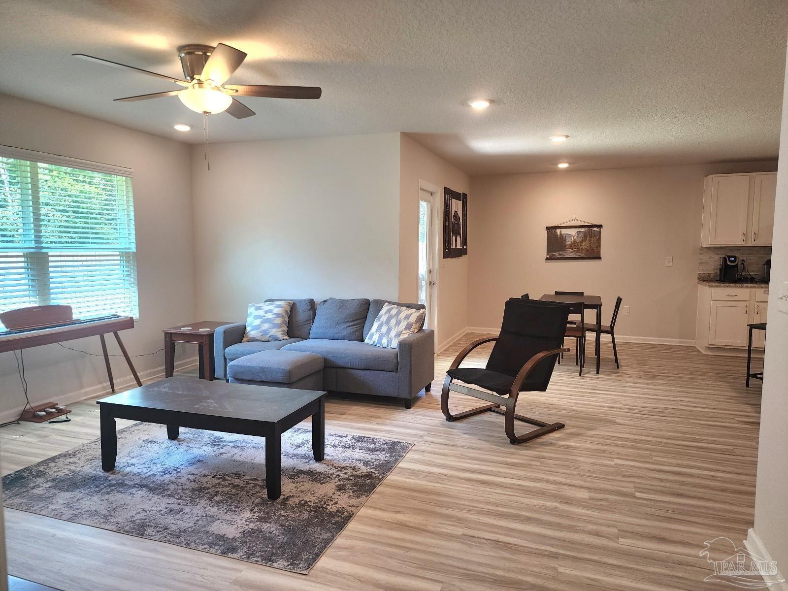 5379 Peach Drive Pace, FL 32571 - Photo 6 of 23 a living room with furniture and a wooden floor