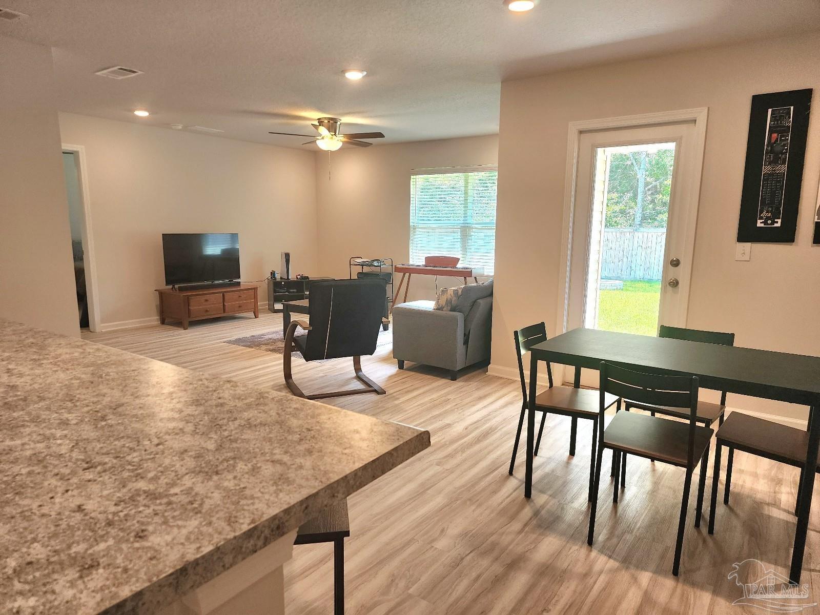 5379 Peach Drive Pace, FL 32571 - Photo 8 of 23 a view of a dining room with furniture window and wooden floor