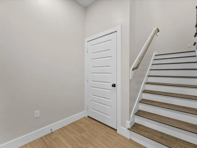 a view of a hallway with wooden floor and entryway