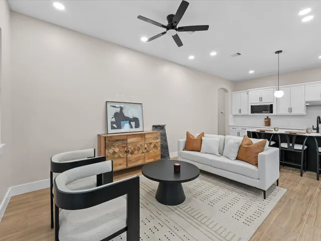 a living room with furniture and a wooden floor