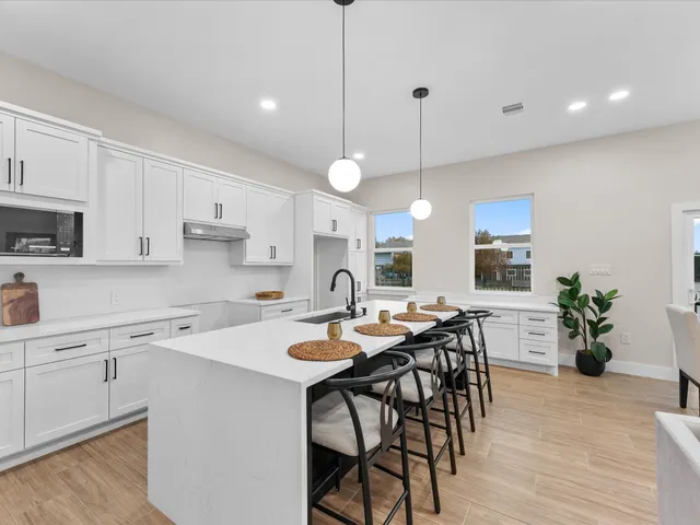 a kitchen with a table chairs microwave and cabinets
