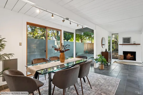 a dining room with furniture a fireplace and wooden floor