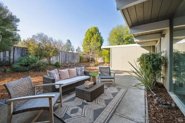 a view of a patio with couches and a table and chairs with wooden fence