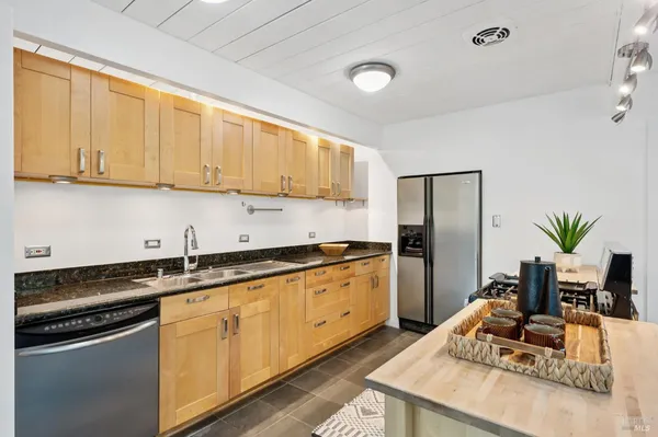 a kitchen with granite countertop a sink stove and refrigerator