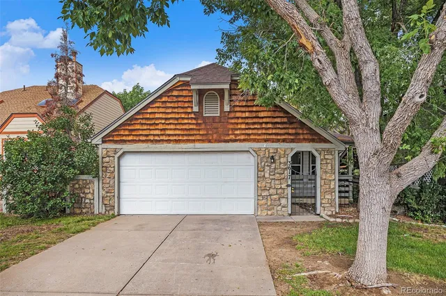 a front view of a house with a garden and garage