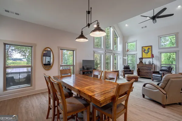 a view of a dining room and livingroom with furniture wooden floor a chandelier