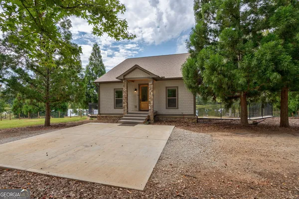 a view of a house with a patio and a yard