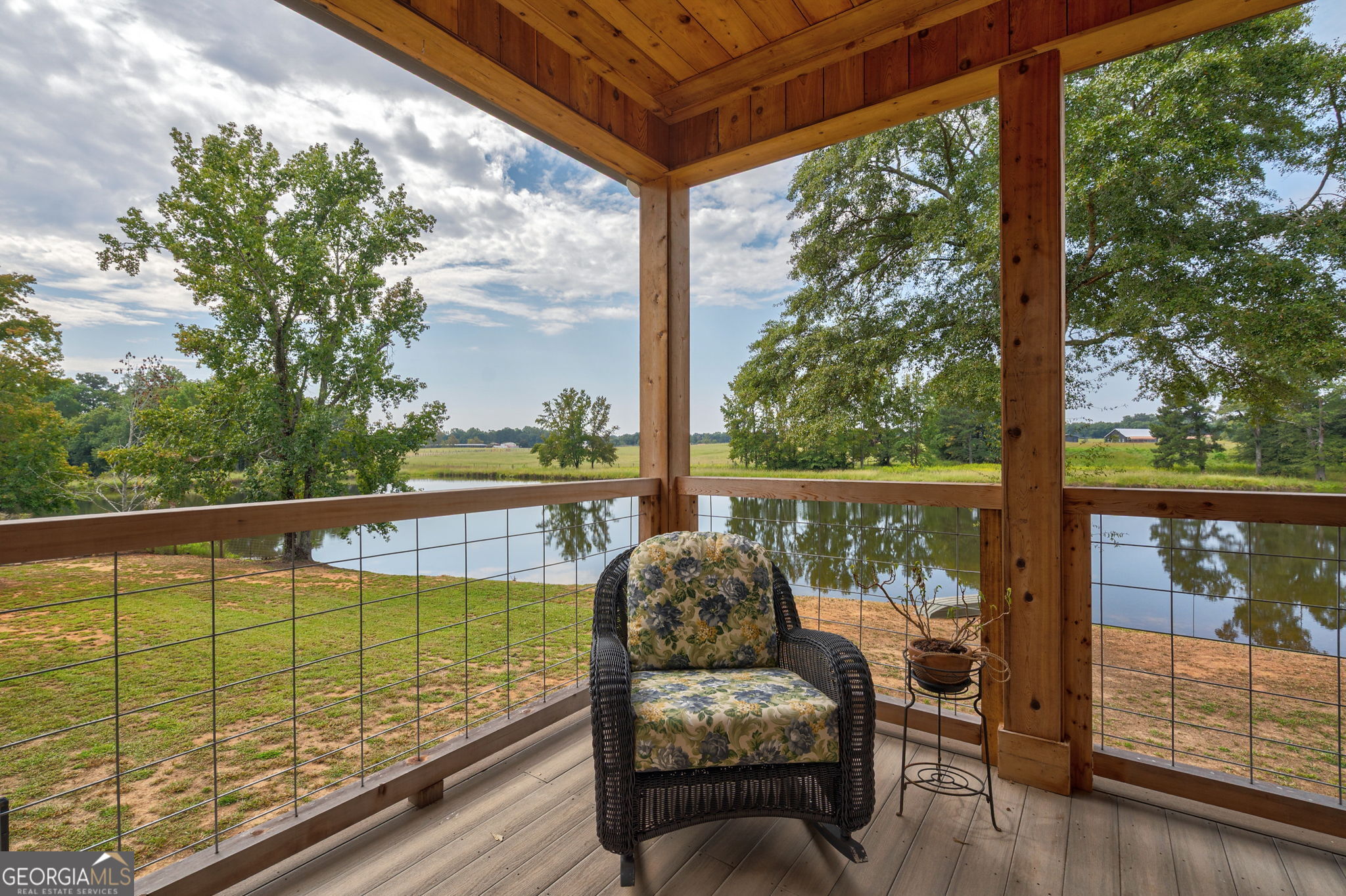 1364 Old Bishop Road Bishop, GA 30621 - Photo 36 of 62 a view of a balcony with table and chairs and wooden floor