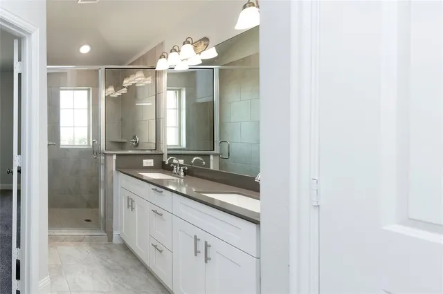 a bathroom with a shower sink vanity granite and mirror