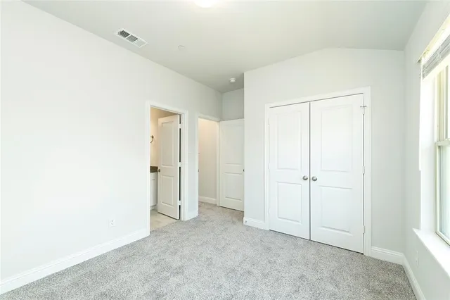 an empty room with windows and closet