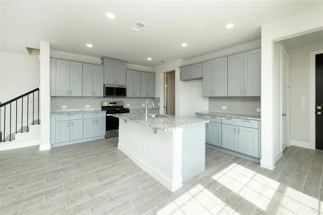 a kitchen with granite countertop white cabinets and white appliances