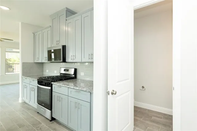 a kitchen with stainless steel appliances granite countertop white cabinets and a sink