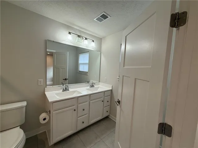 a spacious bathroom with a toilet sink and mirror