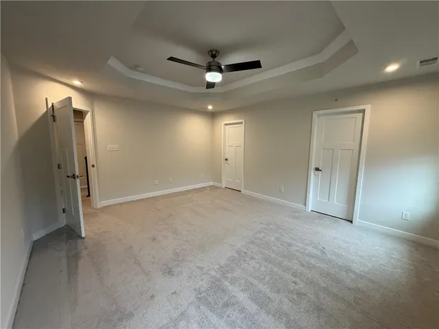 an empty room with closet and a ceiling fan