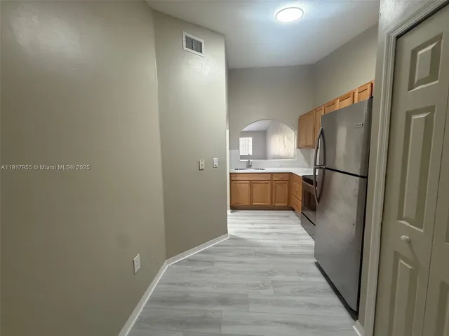 a kitchen with a refrigerator and a sink