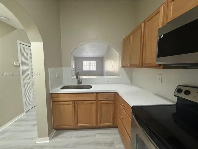 a kitchen with a sink dishwasher a stove and a refrigerator with wooden floor