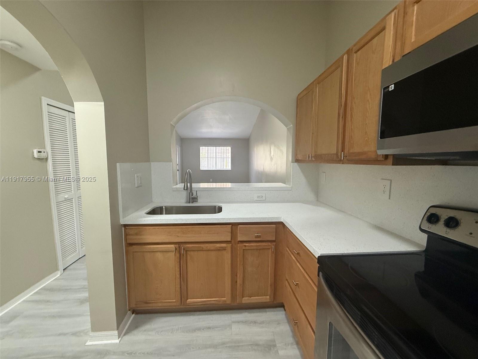 2911 Southeast 13th Road, Unit 20240 Homestead, FL 33035 - Photo 14 of 28 a kitchen with a sink dishwasher a stove and a refrigerator with wooden floor