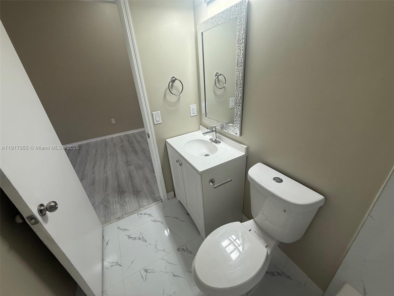 2911 Southeast 13th Road, Unit 20240 Homestead, FL 33035 - Photo 20 of 28 a bathroom with a toilet sink and mirror