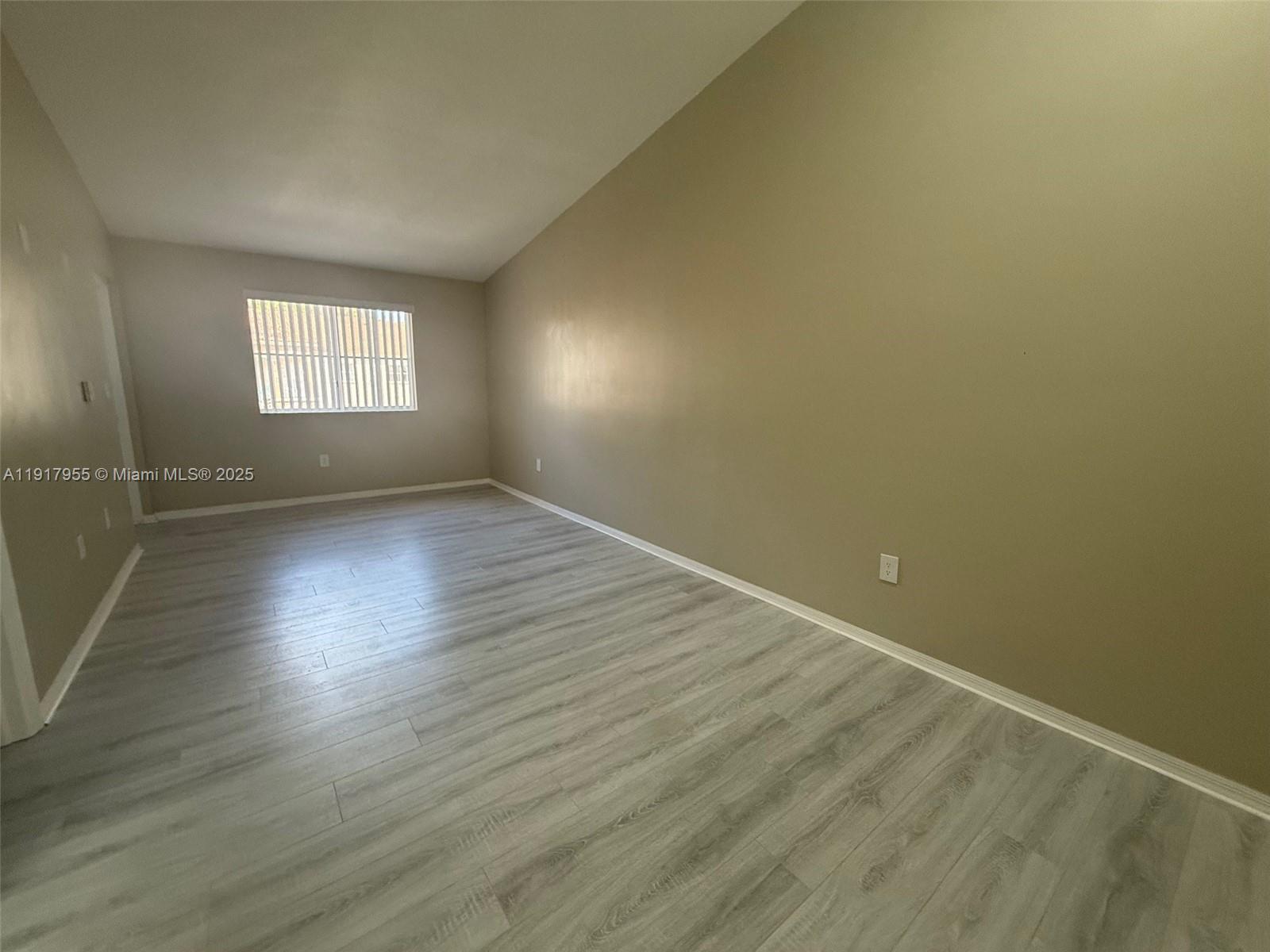 2911 Southeast 13th Road, Unit 20240 Homestead, FL 33035 - Photo 23 of 28 an empty room with wooden floor and windows