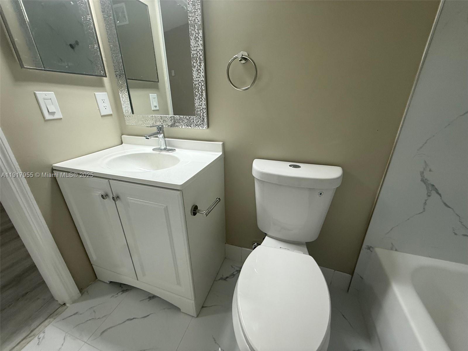 2911 Southeast 13th Road, Unit 20240 Homestead, FL 33035 - Photo 25 of 28 a bathroom with a toilet sink and mirror