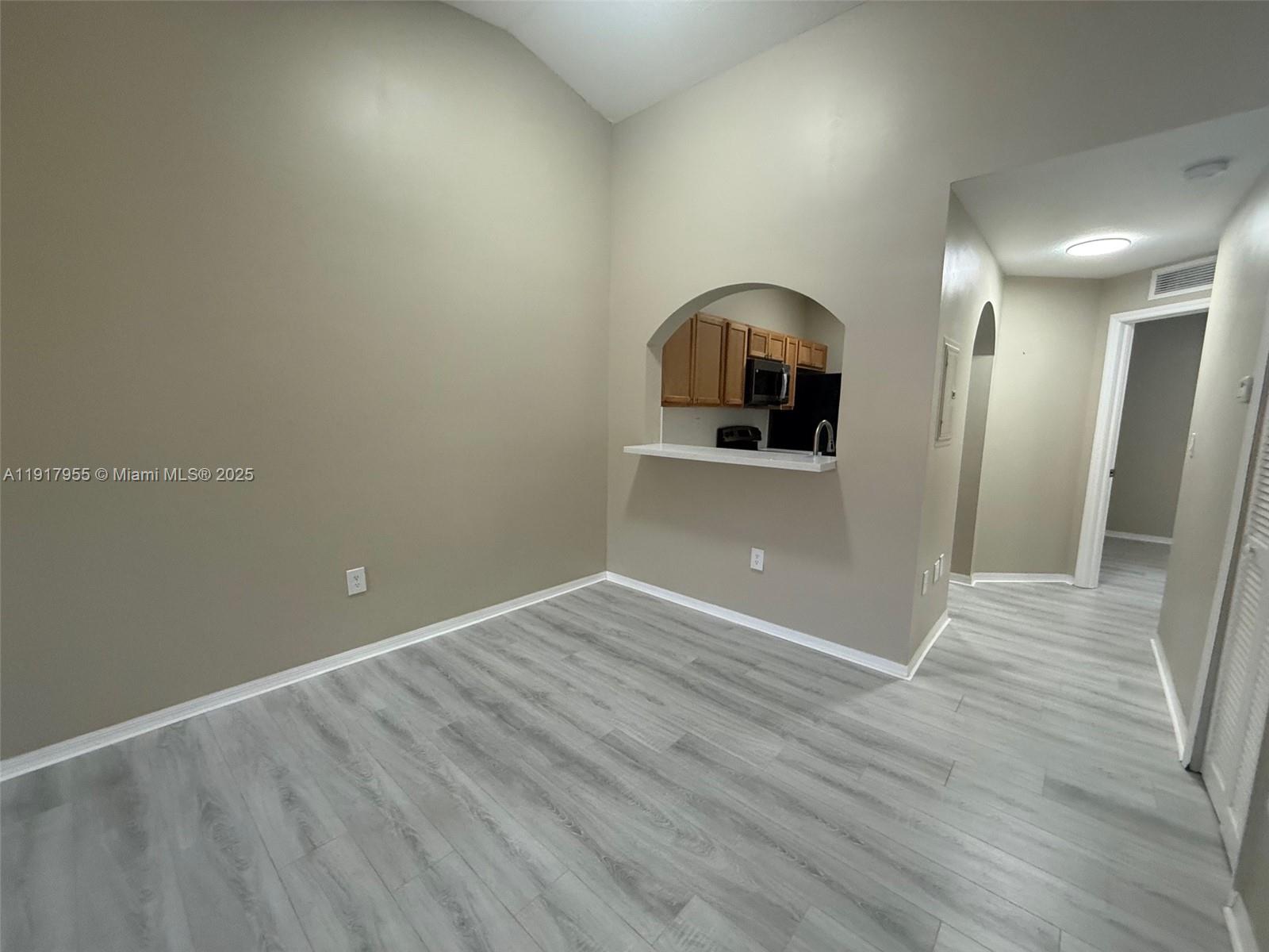 2911 Southeast 13th Road, Unit 20240 Homestead, FL 33035 - Photo 6 of 28 an empty room with wooden floor and mirror