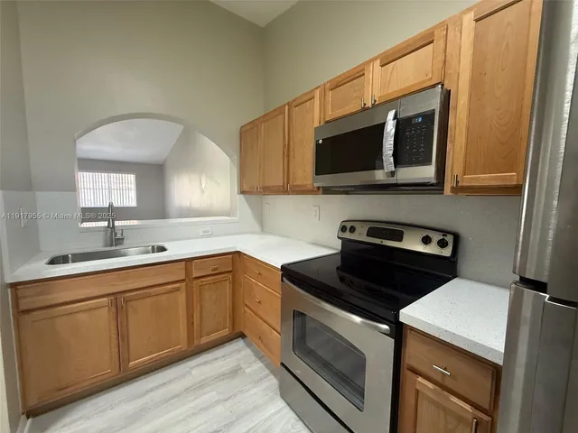 a kitchen with stainless steel appliances a stove microwave and sink