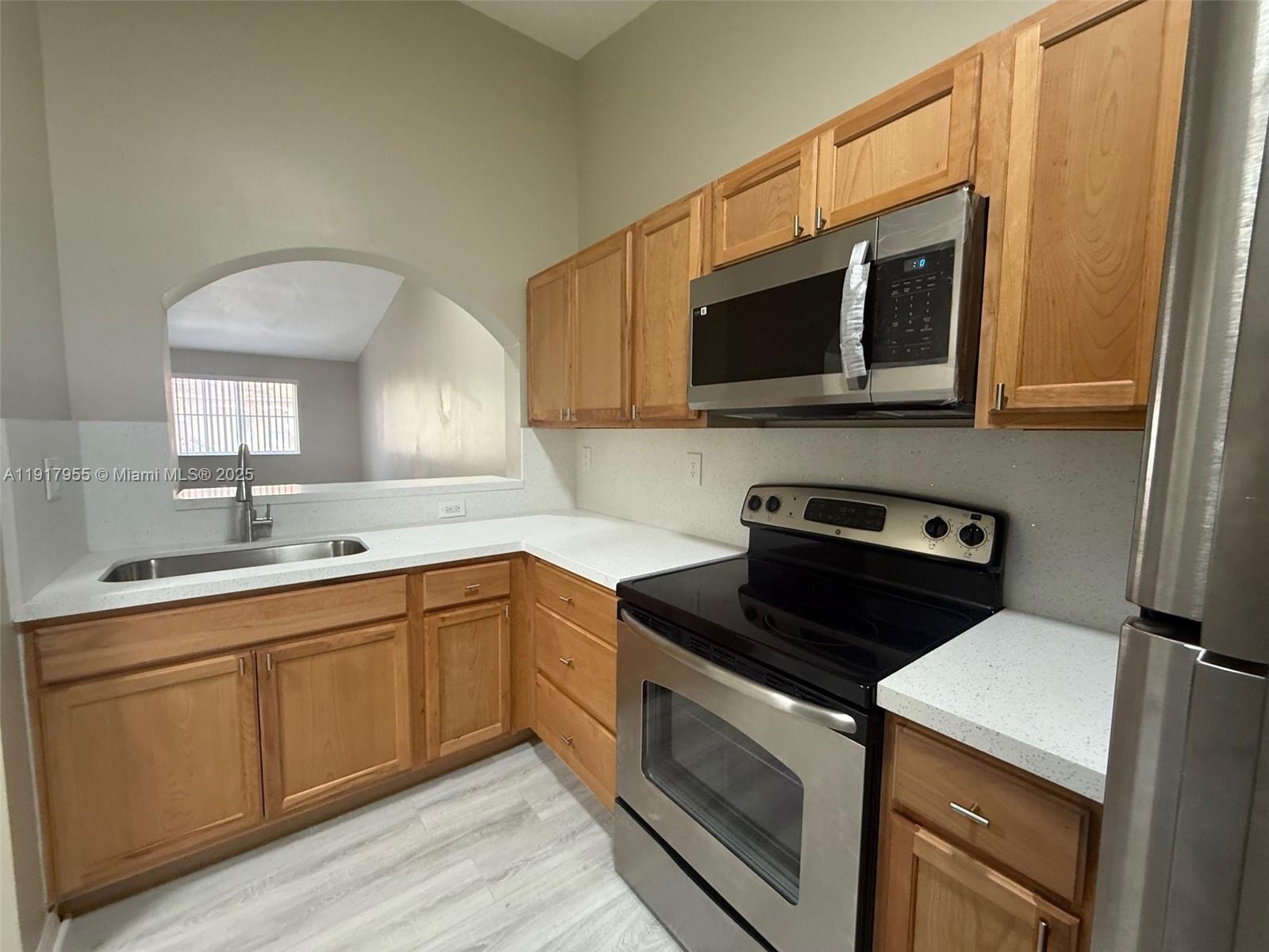 2911 Southeast 13th Road, Unit 20240 Homestead, FL 33035 - Photo 9 of 28 a kitchen with stainless steel appliances a stove microwave and sink
