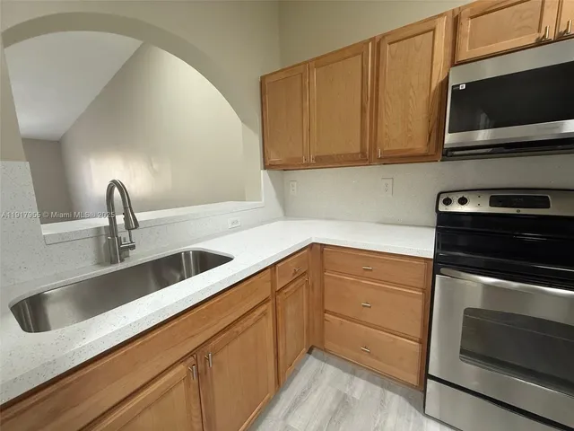 a kitchen with stainless steel appliances granite countertop a sink and a stove top oven