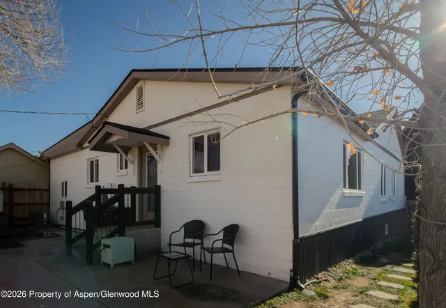 a backyard of a house with table and chairs