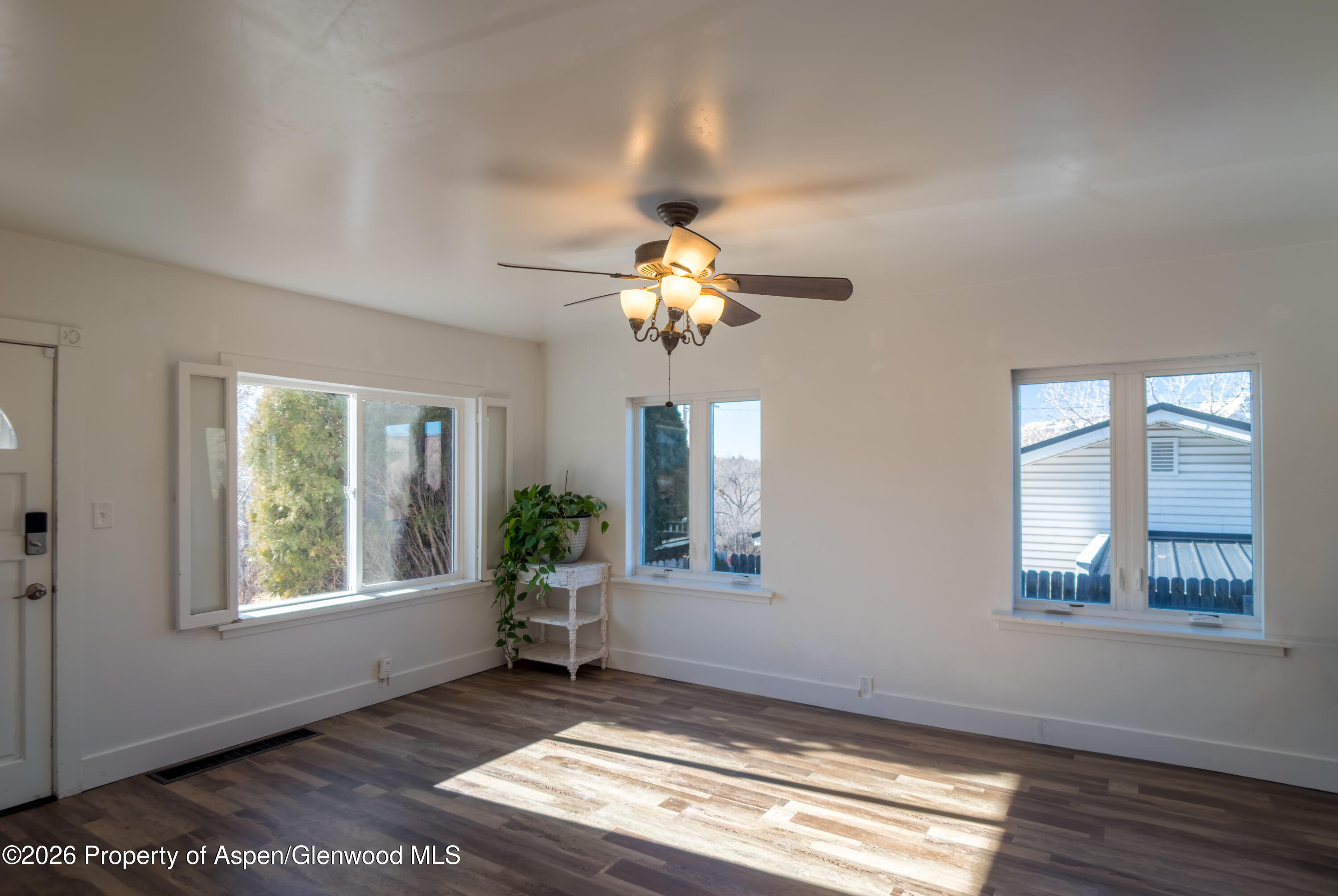 326 East 10th Street Rifle, CO 81650 - Photo 4 of 39 a view of an empty room with wooden floor and a window