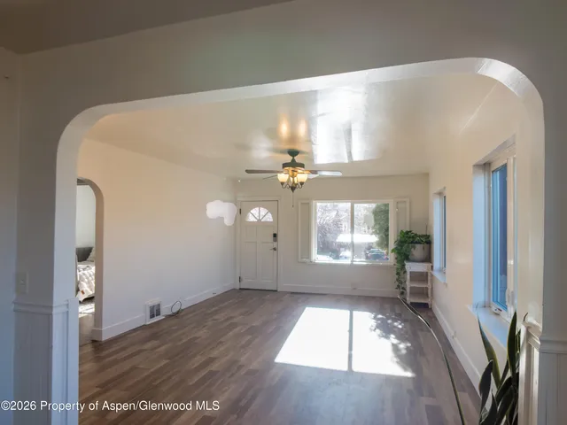 a view of empty room with wooden floor and fan