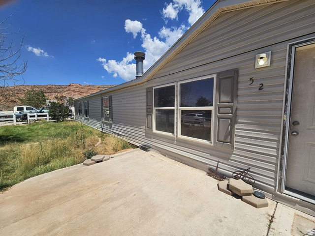 52 Quail Court Moab, UT 84532 - Photo 20 of 36 Light gray vinyl siding exterior with white trim windows and complementary gray shutters
