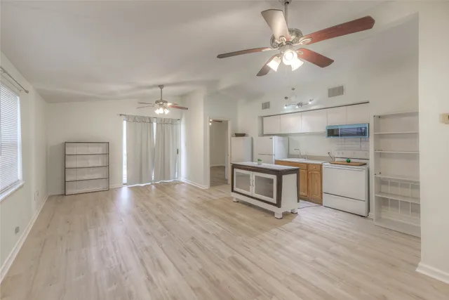 a view of kitchen with granite countertop cabinets and refrigerator