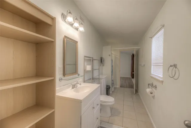 a spacious bathroom with a sink a toilet a shower and a large mirror