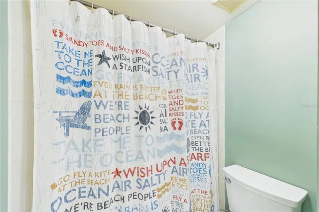 a bathroom with a toilet and shower curtain