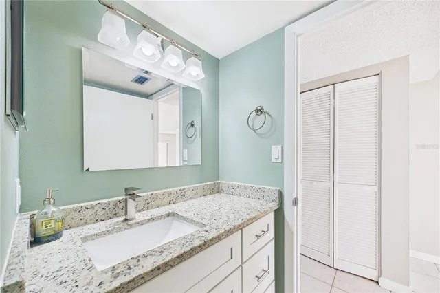 a bathroom with a granite countertop sink and a mirror