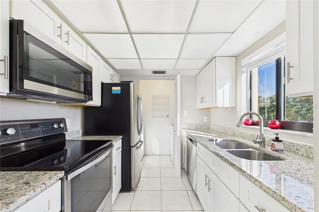 a kitchen with stainless steel appliances granite countertop a sink a stove and a microwave
