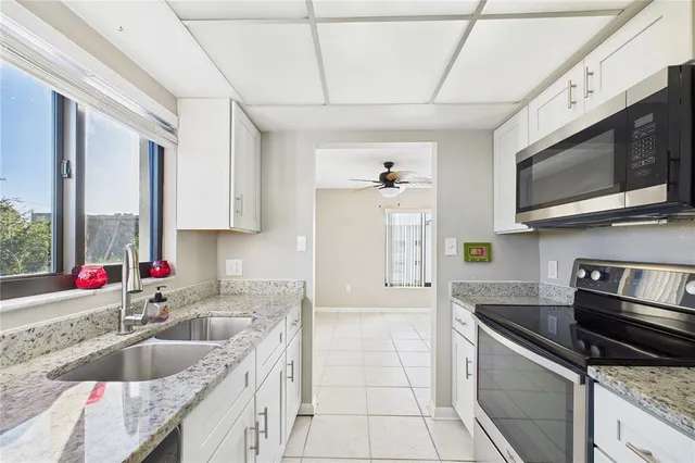 a kitchen with stainless steel appliances granite countertop a sink stove and microwave
