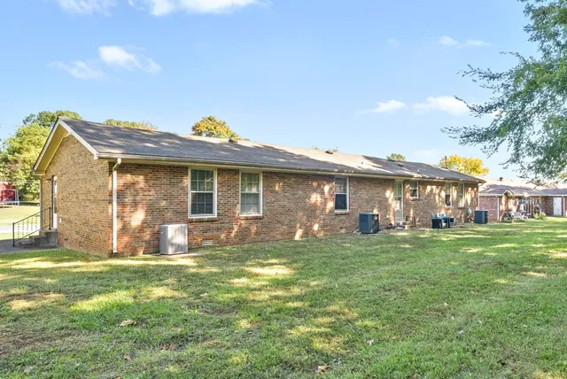 a view of a house with a yard and sitting area