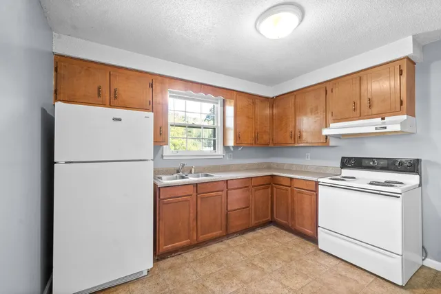 a kitchen with a refrigerator sink and cabinets